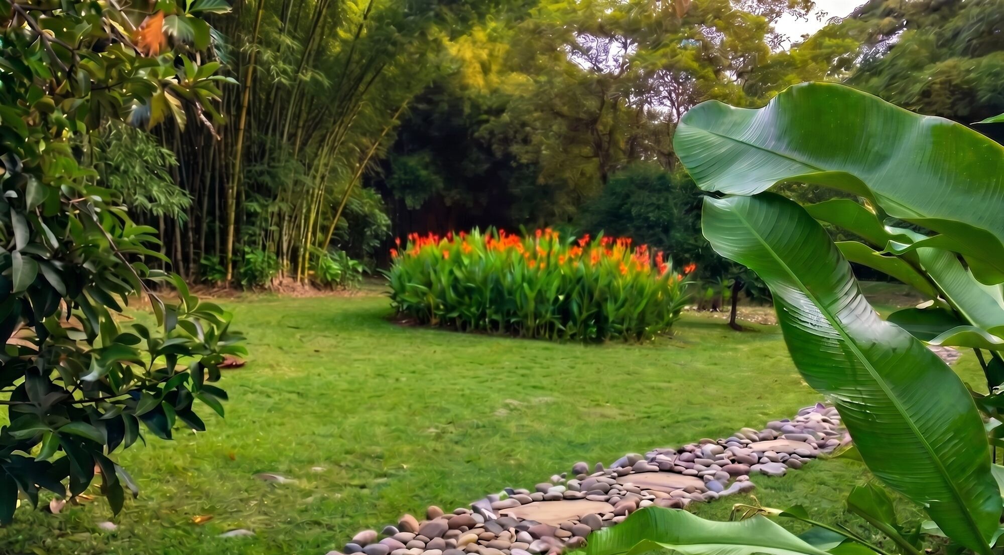 Sendero de piedra húmeda entre heliconias y el bambusal